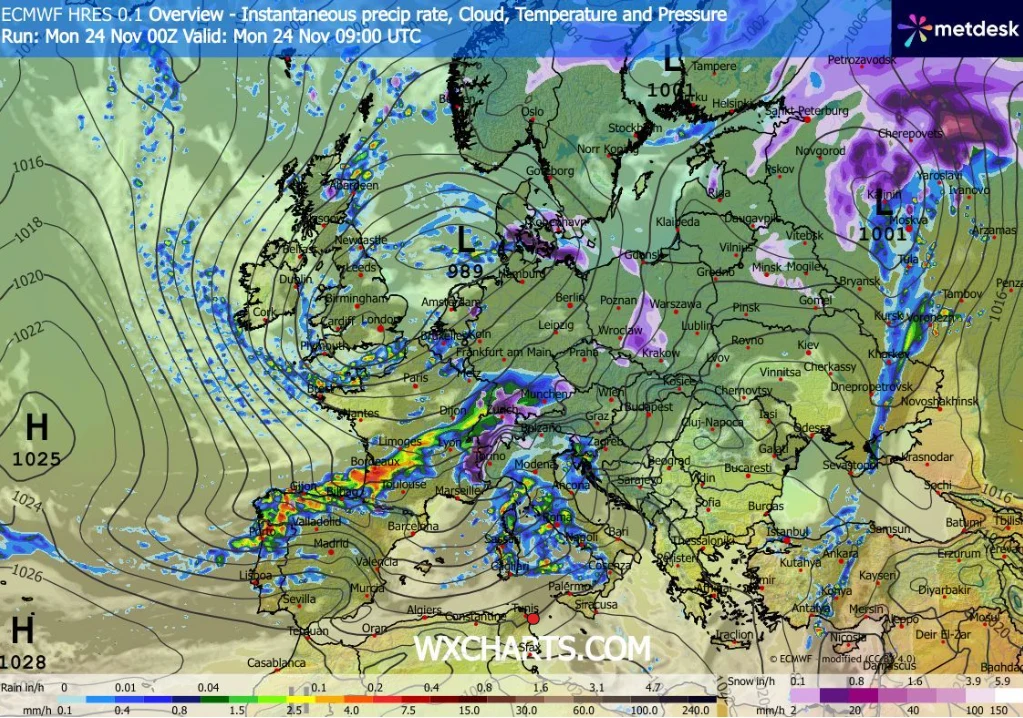 Kolorowa mapa Europy obrazująca aktualne warunki pogodowe z zaznaczoną strefą opadów deszczu i śniegu, systemami frontów atmosferycznych, izobarami oraz wartościami ciśnienia. Wyraźnie zaznaczone masy powietrza i miejsca o silnym wietrze, różne kolory ...