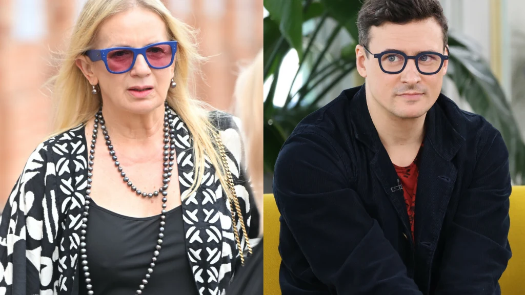 Dwie osoby w średnim wieku, kobieta i mężczyzna, obie mają na sobie okulary oraz eleganckie, casualowe ubrania, tło lekko rozmazane bez wyróżniających się detali.