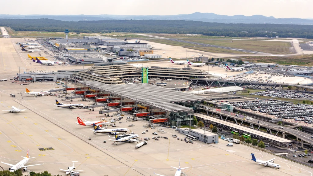 Dwóch Rumunów wtargnęło na płytę lotniska. Chcieli złapać samolot, na który się spóźnili Rozległy terminal lotniska z wieloma stanowiskami dla samolotów oraz gęsto rozmieszczonymi pojazdami i infrastrukturą wokół budynku. Liczne samoloty zaparkowane są przy rękawach, a w tle widoczny jest parking samochodowy oraz pasy startowe. W oddali ro...