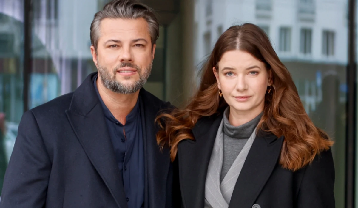 Olivier Janiak i Karolina Malinowska Karolina Malinowska i Olivier Janiak w ciemnych płaszczach pozują na tle nowoczesnego budynku.