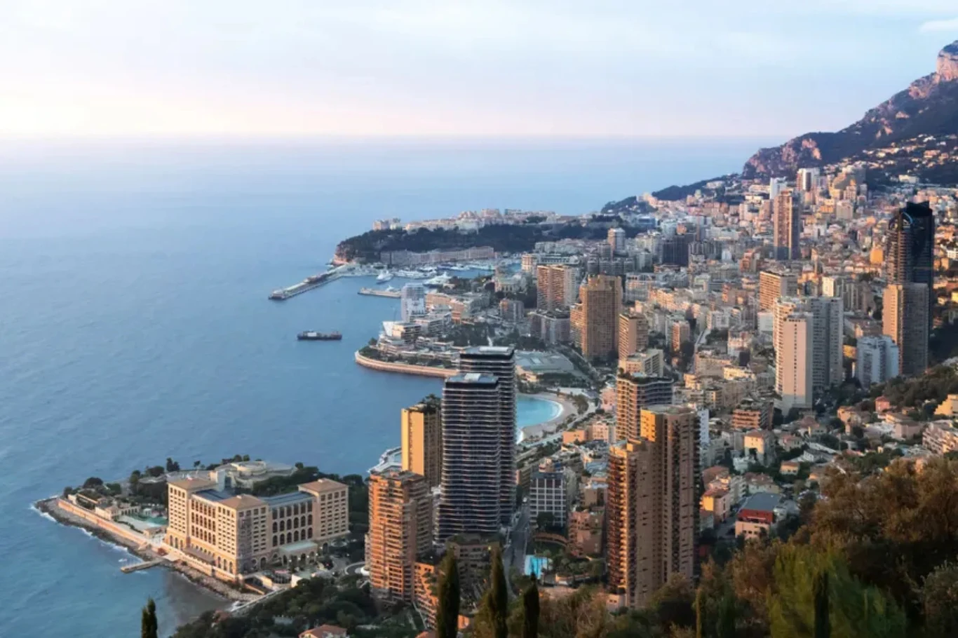 W Monako od dawna trwają dyskusje nad zmianą przepisów drogowych Panorama nadmorskiego miasta z przeważającymi wysokimi budynkami, malowniczym wybrzeżem i otaczającymi wzgórzami. Widoczne są zatoki, port oraz luksusowe apartamentowce położone w pobliżu turkusowego morza.