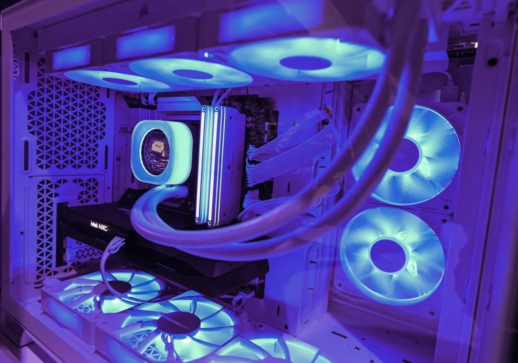 Resort cyfryzacji jest spokojny o finansowanie projektu Bałtyckiej Gigafabryki AI Wnętrze komputera stacjonarnego z podświetlonymi wentylatorami LED w kolorze niebieskim, chłodzeniem wodnym i zainstalowaną kartą graficzną w nowoczesnej obudowie z siatkowanymi panelami wentylacyjnymi.