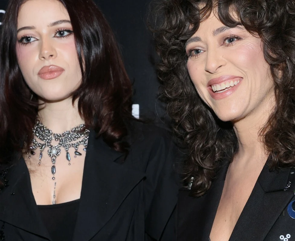 Natalia Kukulska z córką Dwie kobiety ubrane w eleganckie, ciemne stroje, jedna z nich nosi efektowny naszyjnik z ozdobami, obie mają ciemne włosy, jedna z nich się uśmiecha, druga patrzy poważnie.