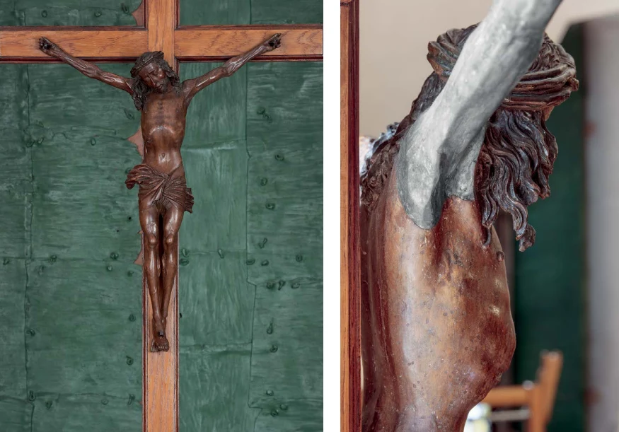 Drewniany krucyfiks z rzeźbioną postacią Jezusa Chrystusa przykutą do krzyża, widoczny na tle zielonej tablicy lub drzwi. Po prawej stronie zbliżenie na detale rzeźby, ukazujące fragment torsu, ramienia i głowy.