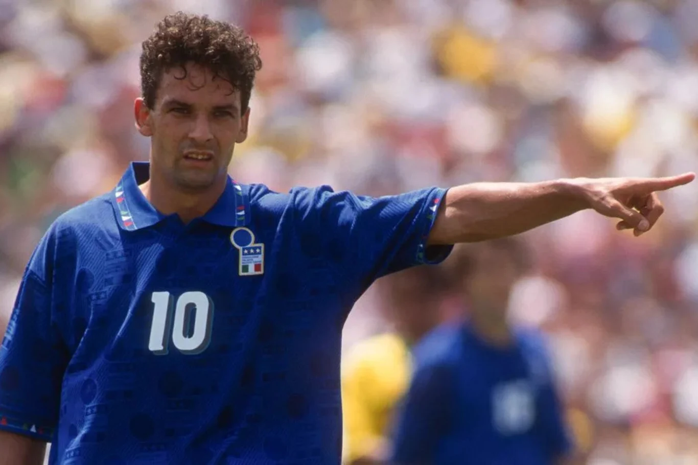 Idolem zakonnicy był wicemistrz świata z 1994 r. Roberto Baggio Piłkarz w niebieskiej koszulce z numerem 10 wskazuje ręką kierunek na boisku, w tle rozmyta publiczność i zawodnicy.