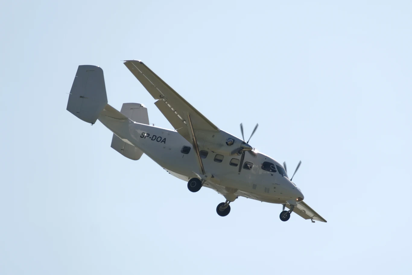 Zakłady w Mielcu podpisały umowę na dostawy samolotów M28 do Niemiec Samolot turbośmigłowy w locie na tle jasnego nieba, widoczne podwozie oraz numer boczny SP-DQA na kadłubie.