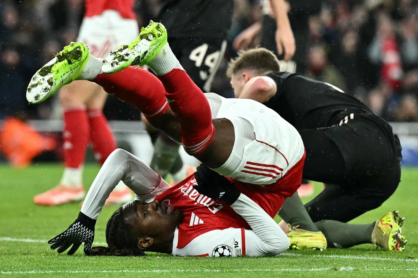 Bywały momenty, w których piłkarze Arsenalu kontrowali przebieg boiskowych zdarzeń w stopniu umiarkowanym Piłkarz w czerwono-białym stroju leży na murawie stadionu po upadku, trzymając się za nogę, a jego ciało jest wygięte w nienaturalnej pozycji. W tle drugi zawodnik pochyla się nad nim.