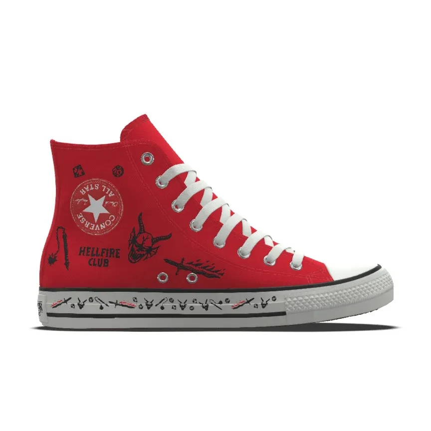 Converse Chuck Taylor All Star x Stranger Things Czerwony trampki marki Converse z wysoką cholewką, ozdobiony białymi sznurówkami oraz nadrukami w czarnym i białym kolorze, w tym motywami z napisem Hellfire Club oraz grafikami utrzymanymi w stylu nawiązującym do popkultury.