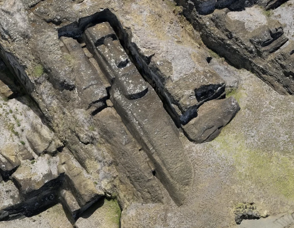 Duży wykuty w kamieniu obiekt przypominający kształtem łódź lub łuk otoczony surową strukturą skalną, widoczny z lotu ptaka, z wyraźnymi prostokątnymi wycięciami po jego bokach.