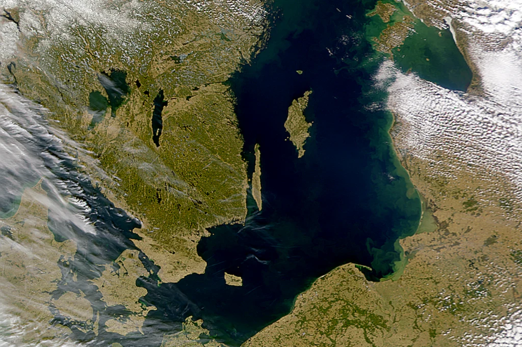 Satelitarny widok Morza Bałtyckiego otoczonego przez lądowe tereny Skandynawii i Europy Środkowej, w centrum wyspa Gotlandia, wyraźnie widoczne linie brzegowe i zróżnicowane połacie zieleni na lądzie.