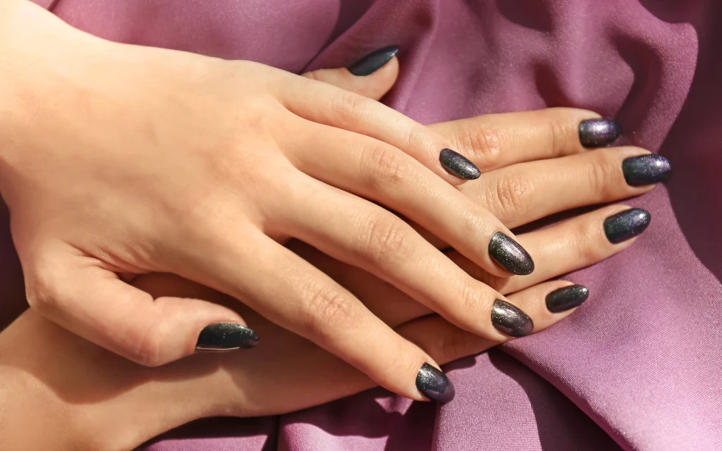 Czarne paznokcie z brokatem to manicure z pazurem