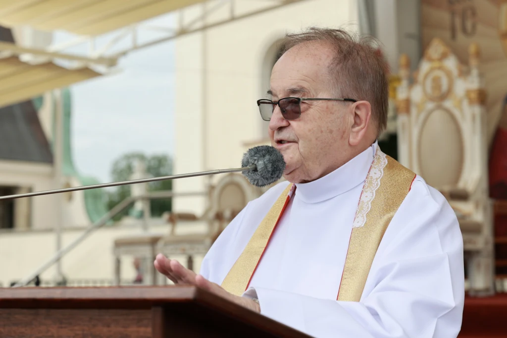 CBA weszło do fundacji Tadeusza Rydzyka Starszy duchowny w okularach wygłasza przemówienie przy mikrofonie podczas uroczystości na tle dekoracji sakralnej.