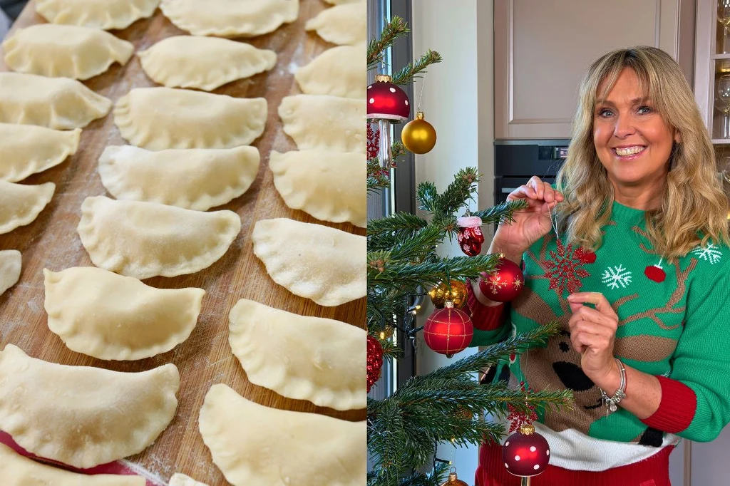 Część świątecznych potraw można przygotować wcześniej Rząd pierogów przygotowanych do gotowania na drewnianej powierzchni obok kobiety w świątecznym swetrze, dekorującej choinkę czerwonymi i złotymi bombkami.