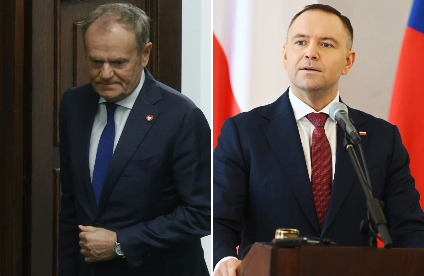 Dwóch mężczyzn ubranych w garnitury, jeden stoi w pomieszczeniu przy mikrofonie, a drugi opiera się o drzwi, na obu widoczne przypinki z flagą Polski.