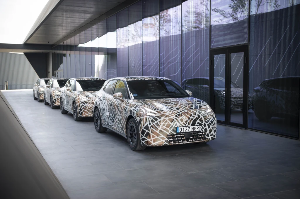 Raval w wariancie VZ dysponuje mocą 226 KM i momentem obrotowym 290 Nm. Cztery zamaskowane samochody stojące w szeregu przed nowoczesnym budynkiem z przeszkloną elewacją, odbijającą otoczenie.