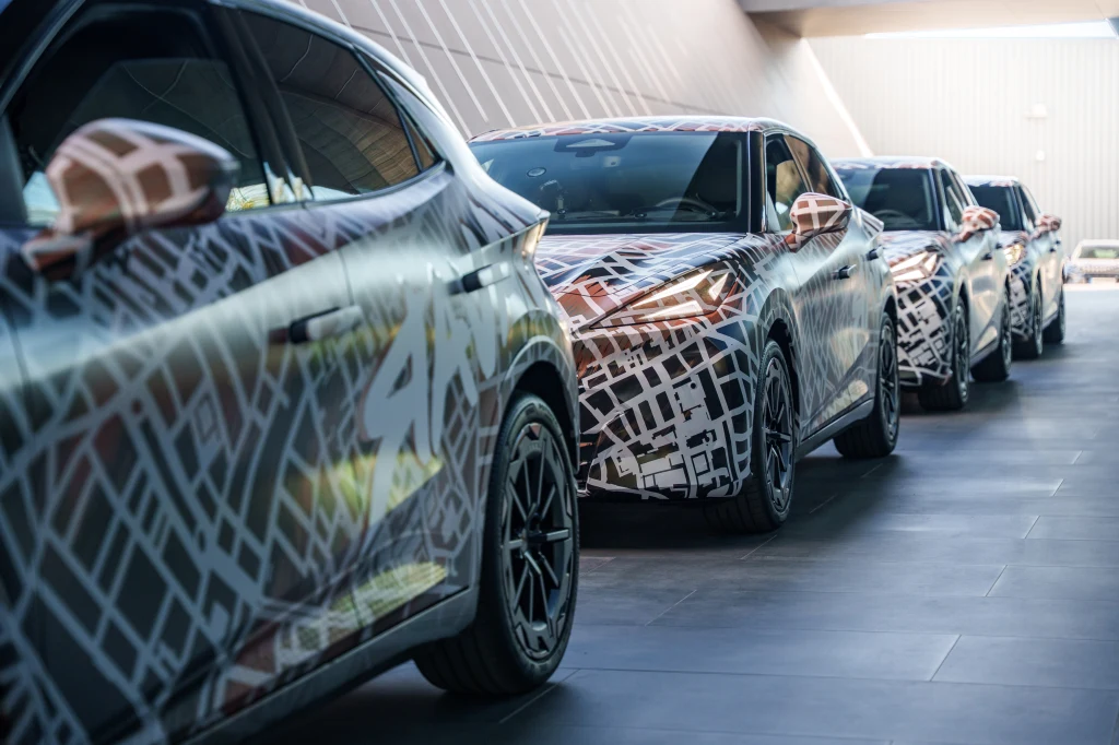 To właśnie wariant VZ został mi udostępniony do krótkich jazd testowych. Szereg nowoczesnych samochodów pokrytych kamuflażem testowym, ustawionych jeden za drugim w jasnym, nowoczesnym tunelu, światło wpada przez otwartą przestrzeń na końcu przejazdu.