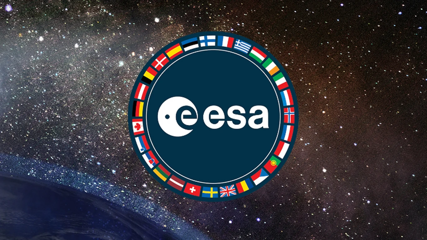 Polska na całego stawia na kosmos. Cel to ośrodek ESA w naszym kraju Logo Europejskiej Agencji Kosmicznej otoczone flagami państw członkowskich, umieszczone na tle gwiazd i fragmentu planety, co podkreśla międzynarodową współpracę w zakresie badań kosmicznych.