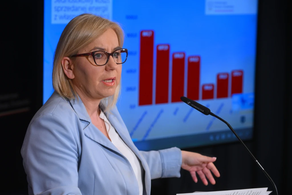 Paulina Hennig-Kloska poinformowała, że zamierza wystartować w wyborach na przewodniczącego Polski 2050 Kobieta w okularach podczas wystąpienia na tle ekranu z wykresem słupkowym w kolorze czerwonym oraz tekstem, ubrana w jasnoniebieską marynarkę, trzyma dokumenty i mówi do mikrofonu.