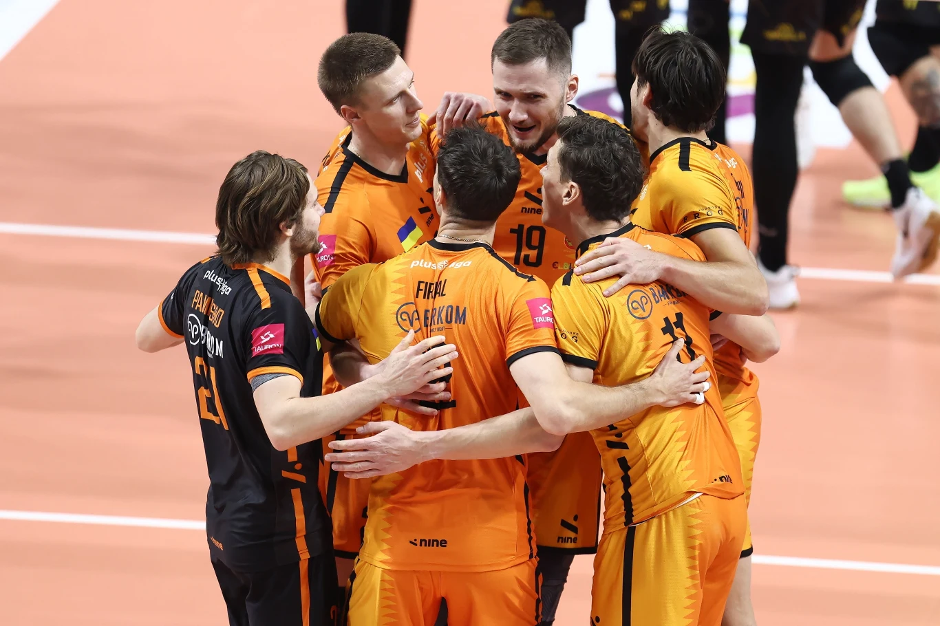 Siatkarze Barkomu Każany Lwów przełamali serię porażek Grupa siatkarzy ubranych w pomarańczowe stroje świętuje zdobycie punktu na boisku, obejmując się i wyrażając radość z sukcesu drużynowego.