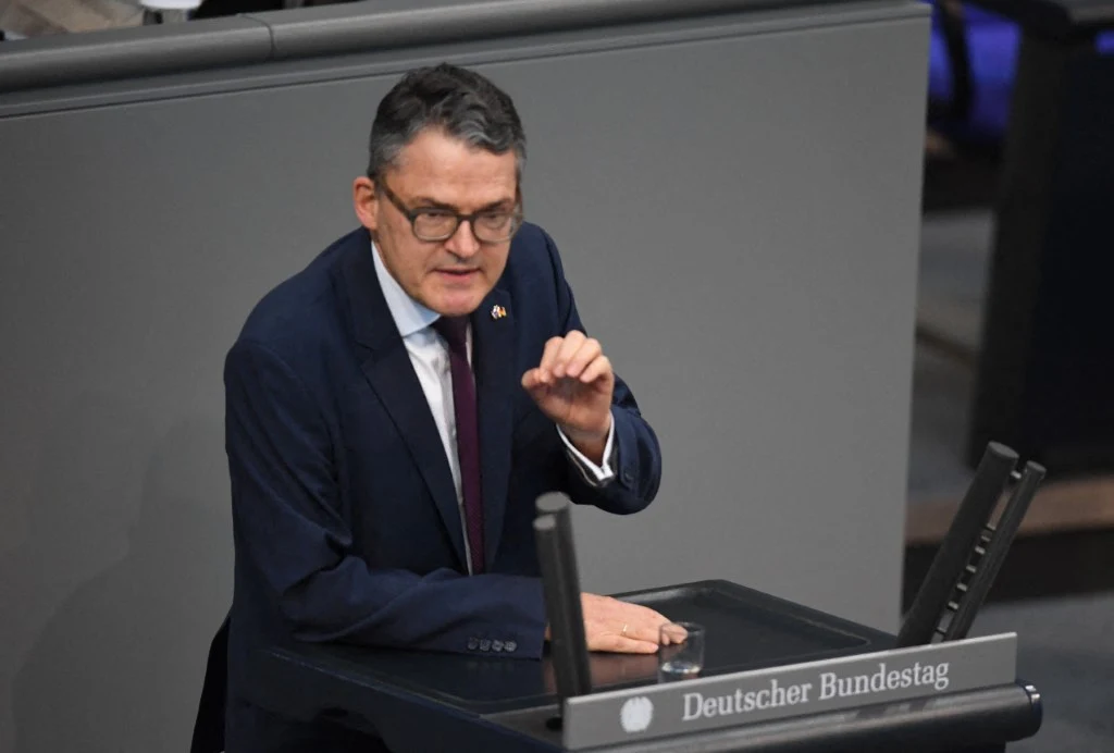 Kiesewetter skomentował sprawę reparacji od Niemiec, gazociągu Nord Stream i obecność USA w Europie Mężczyzna w garniturze i okularach przemawia za mównicą w niemieckim Bundestagu, gestykulując jedną ręką, skupiony na przekazie.