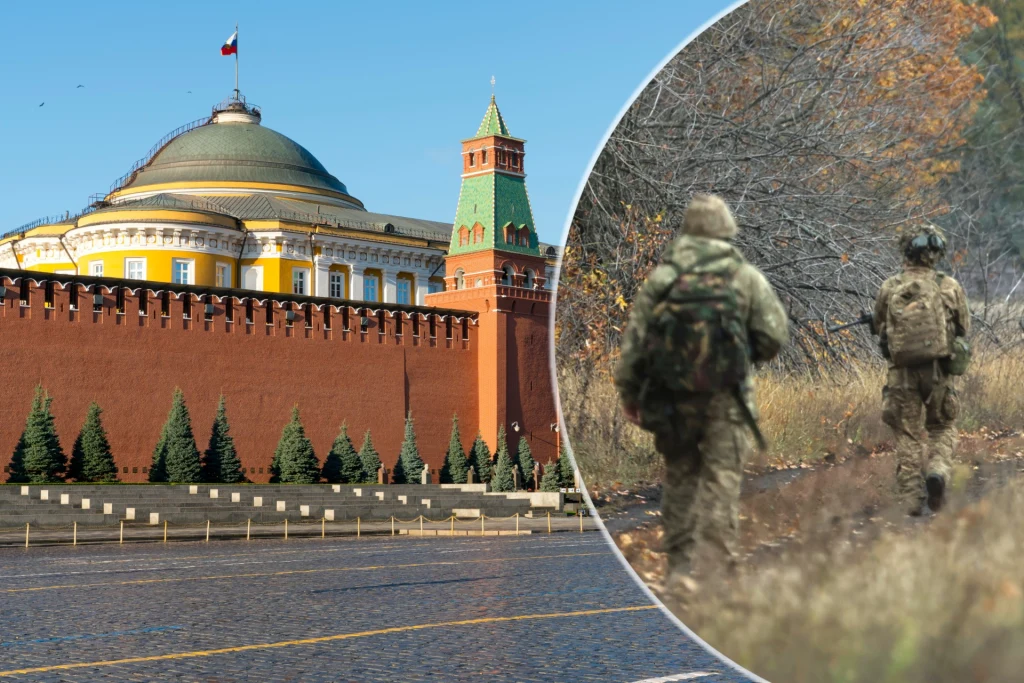 Po lewej stronie znajduje się historyczna część murów Kremla z charakterystyczną wieżą i rosyjską flagą. Po prawej widoczne są sylwetki dwóch żołnierzy w mundurach idących przez leśny teren, w jesiennej scenerii.