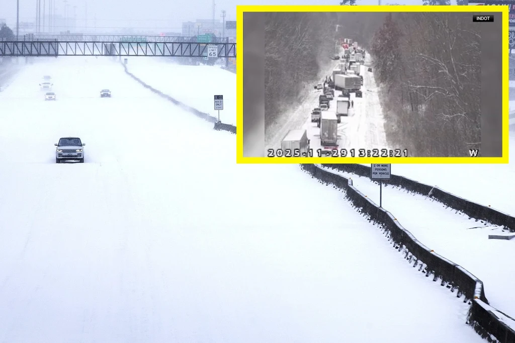 Ośnieżona autostrada z zaledwie kilkoma pojazdami jadącymi w jednym kierunku, większość jezdni pusta. W prawym górnym rogu umieszczono powiększenie z kamery drogowej, pokazujące długi korek samochodów ciężarowych i osobowych stojących w zaspach śnieżny...