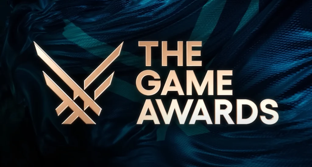 Logo The Game Awards z nowoczesną grafiką w tle, złote litery i stylizowany symbol skrzydeł na ciemnoniebieskim tle.