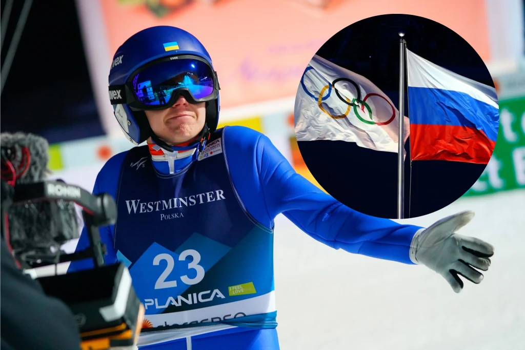 Zbliżenie sportowca w niebieskim kombinezonie z numerem 23 oraz logiem zawodów narciarskich, po bokach widoczna kamera transmisyjna. W prawym górnym rogu okrągłe wstawienie przedstawiające flagę olimpijską i rosyjską na jednym maszcie.