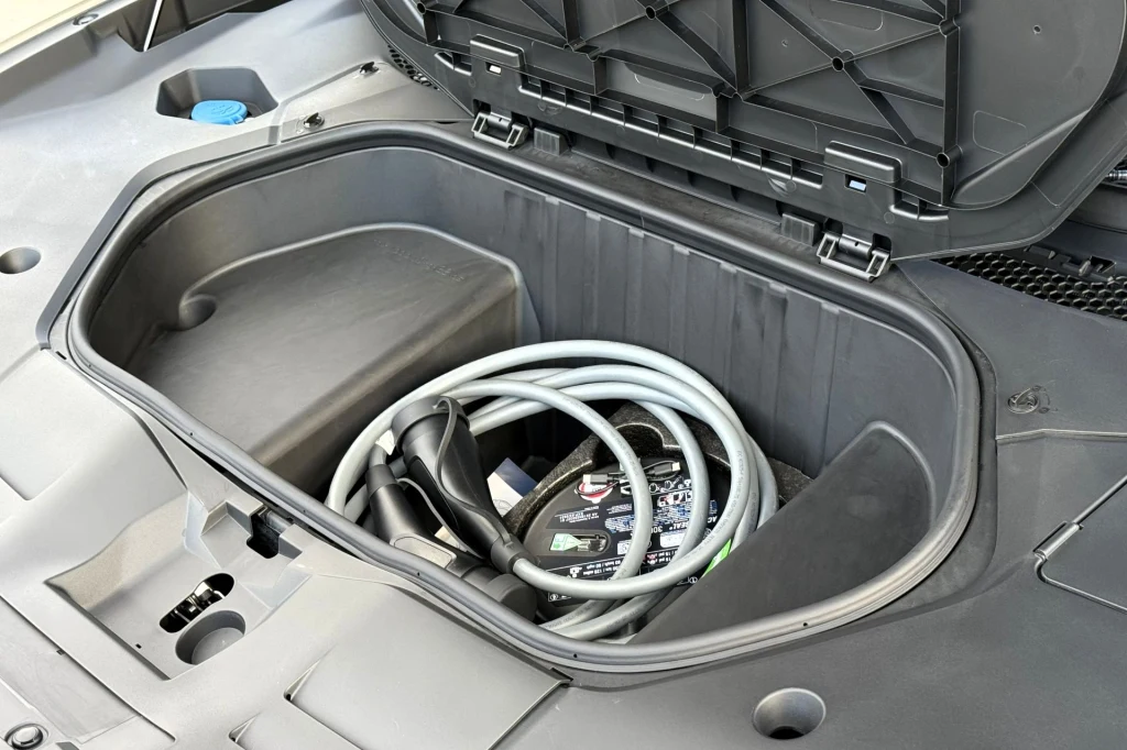 Pod maską znajdziemy 58-litrowy schowek, który możemy wykorzystać do przechowywania kabli do ładowania. Przedni schowek samochodu elektrycznego, w którym znajduje się kabel do ładowania oraz akcesoria motoryzacyjne.