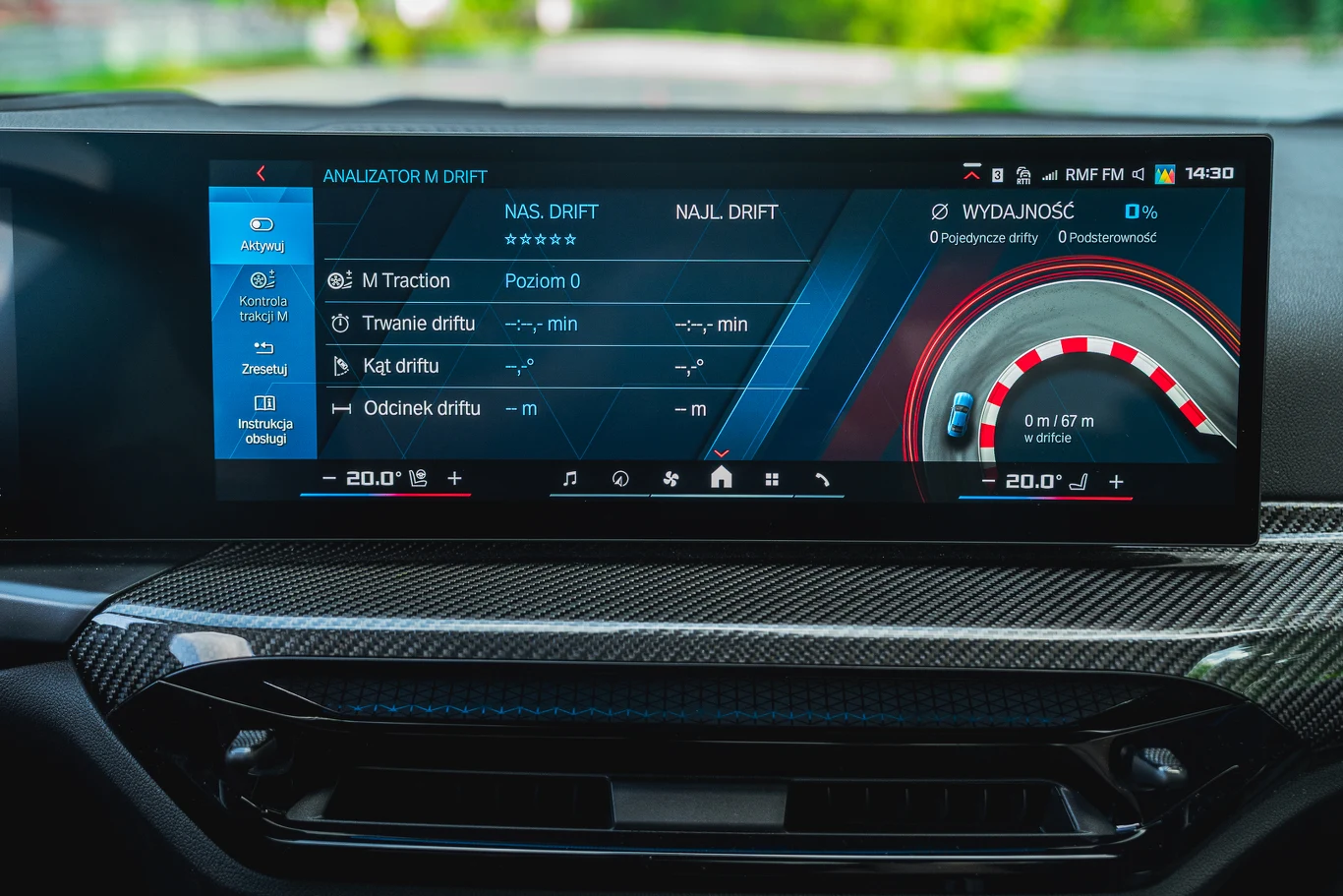 BMW M2 Cyfrowy wyświetlacz kokpitu samochodu z informacjami dotyczącymi analizy driftu, parametrów jazdy oraz wydajności, otoczony elementami konsoli środkowej z karbonowym wykończeniem i widocznymi cyfrowymi wskaźnikami.