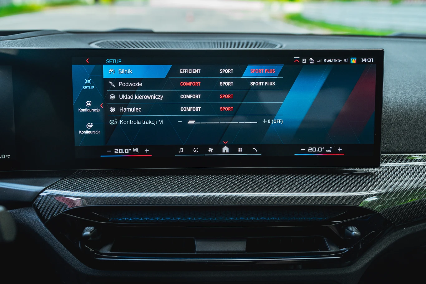 BMW M2 Ekran komputera pokładowego samochodu z menu konfiguracji ustawień jazdy w tym silnika, podwozia, układu kierowniczego, hamulców i kontroli trakcji z opcjami trybów Komfort, Sport i Sport Plus.