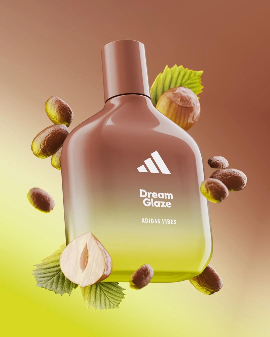 Butelka perfum Adidas Dream Glaze utrzymana w brązowych i żółtozielonych odcieniach, otoczona całymi oraz przekrojonymi orzechami laskowymi, z delikatnym gradientowym tłem w ciepłych kolorach.