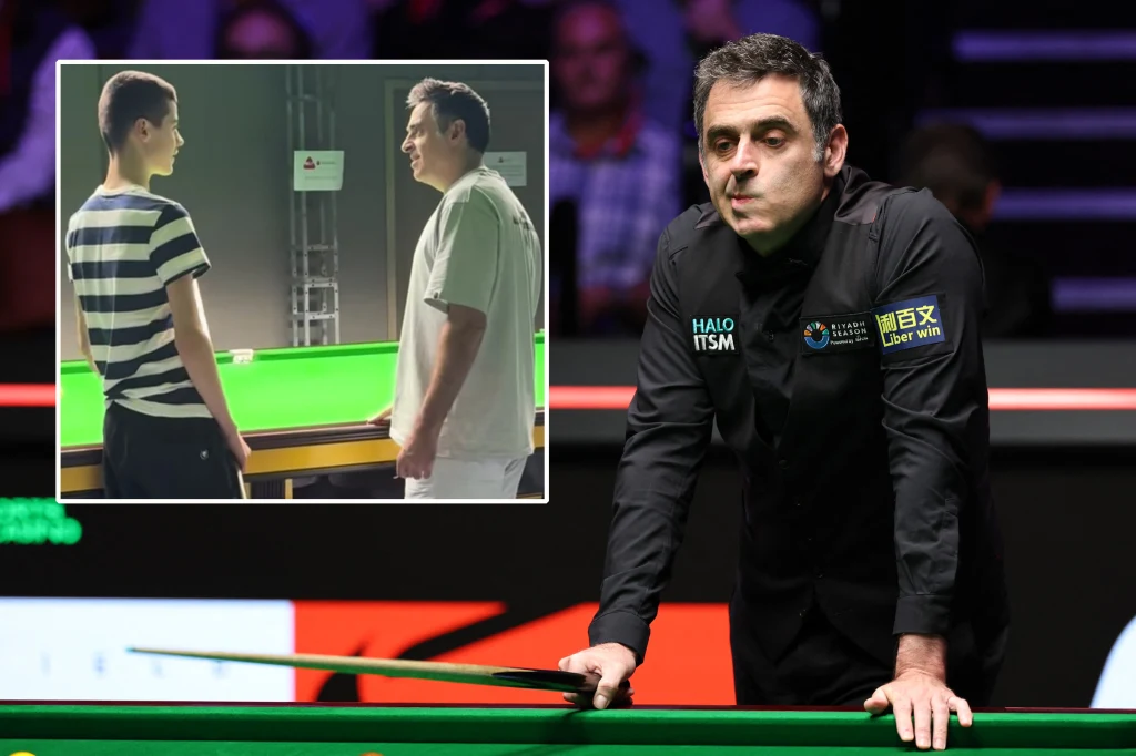 Mężczyzna w ciemnym stroju sportowym opiera się o stół bilardowy w oświetlonym pomieszczeniu, na drugim planie wyraźnie widoczni sędziowie oraz widownia, w lewym górnym rogu wstawka ukazująca dwóch mężczyzn stojących naprzeciw siebie przy stole bilardo...