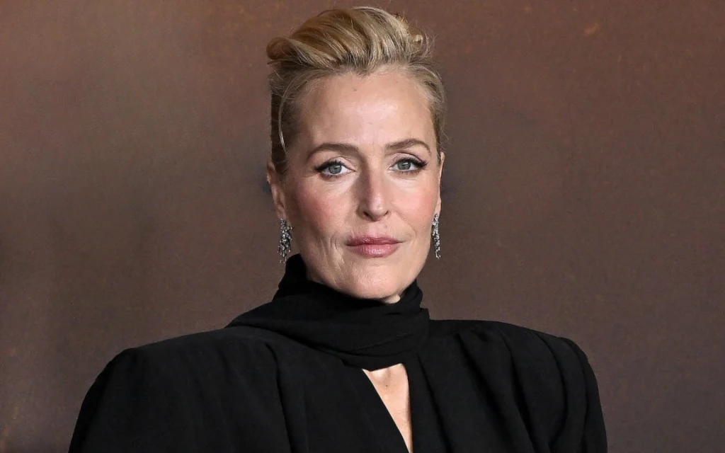Aktorka Gillian Anderson w czarnej sukience ze stójką i upiętych do góry włosach
