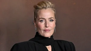 Aktorka Gillian Anderson w czarnej sukience ze stójką i upiętych do góry włosach