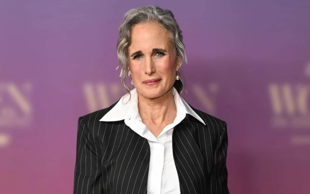 Aktorka Andie MacDowell w spiętych włosach w siwym kolorze, białej koszuli i marynarce w prążki