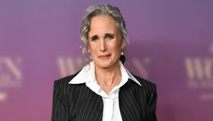 Aktorka Andie MacDowell w spiętych włosach w siwym kolorze, białej koszuli i marynarce w prążki