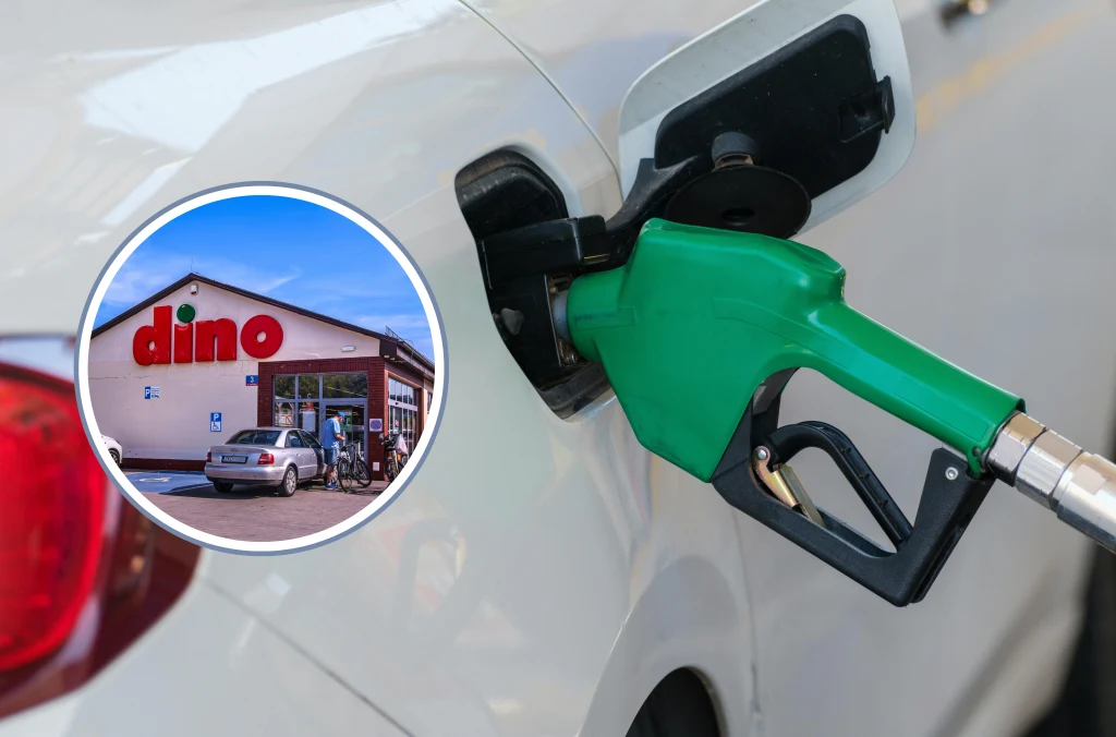 Samochód tankowany zieloną pistoletem przy dystrybutorze paliw oraz sklep Dino widoczny w okrągłym kadrze, na którym znajdują się zaparkowane samochody i wejście główne do sklepu.