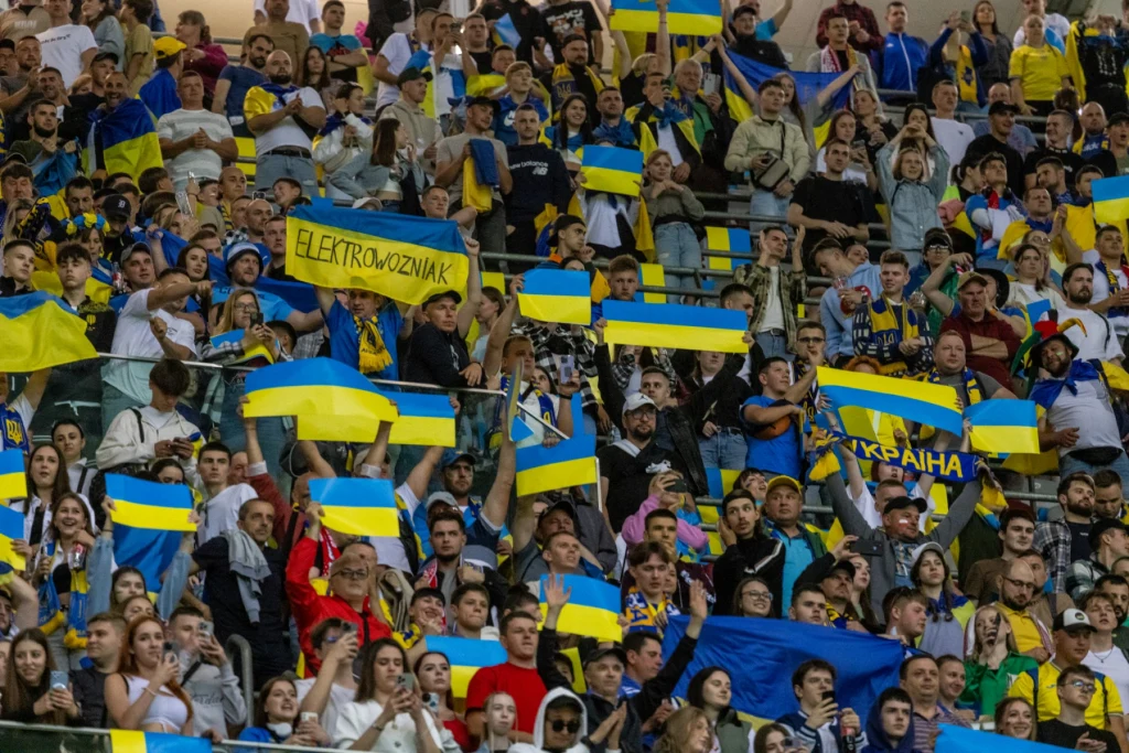 Ukraińcy chcą drugi raz w historii zagrać na MŚ Tłum ludzi zgromadzonych na trybunach, większość trzyma ukraińskie flagi i transparenty, panuje atmosfera wsparcia i jedności.