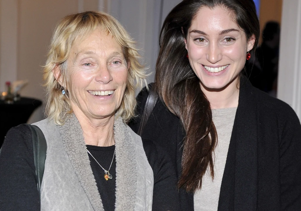 Małgorzata Braunek i Orina Krajewska Dwie kobiety stoją obok siebie i uśmiechają się do kamery, starsza ma jasne włosy, a młodsza długie, ciemne włosy. Obie ubrane są w codzienne ubrania, w tle widoczne jest wnętrze pomieszczenia.