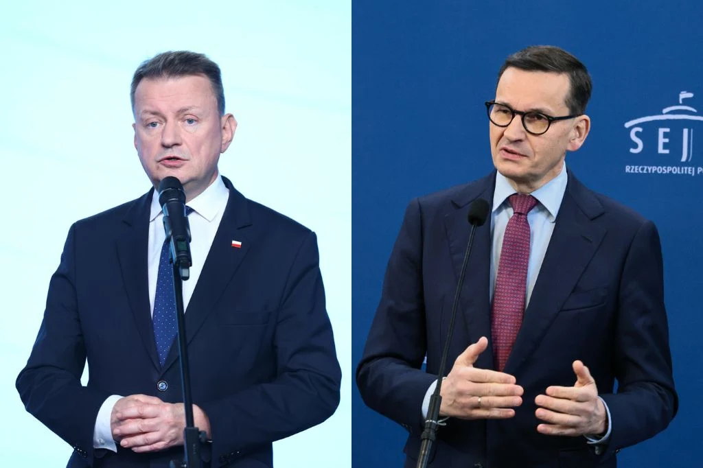 Mariusz Błaszczak i Mateusz Morawiecki Dwóch mężczyzn w garniturach wygłasza przemówienia przy mikrofonach na tle jasnym i niebieskim z elementami oznaczeń państwowych.
