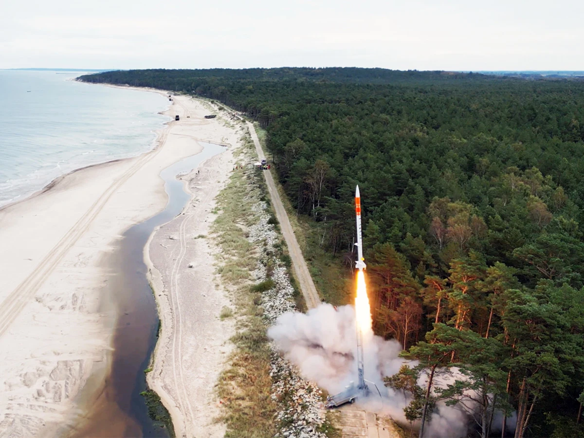 Rakieta suborbitalna PERUN od SpaceForest odbyła w listopadzie br. trzeci lot testowy, startując z Ustki Rakieta startująca z leśnej polany tuż przy wybrzeżu morskim, nad którą unosi się dym po odpaleniu silnika. W tle rozpościera się morze oraz szeroka plaża, po stronie przeciwnej – gęsty las.