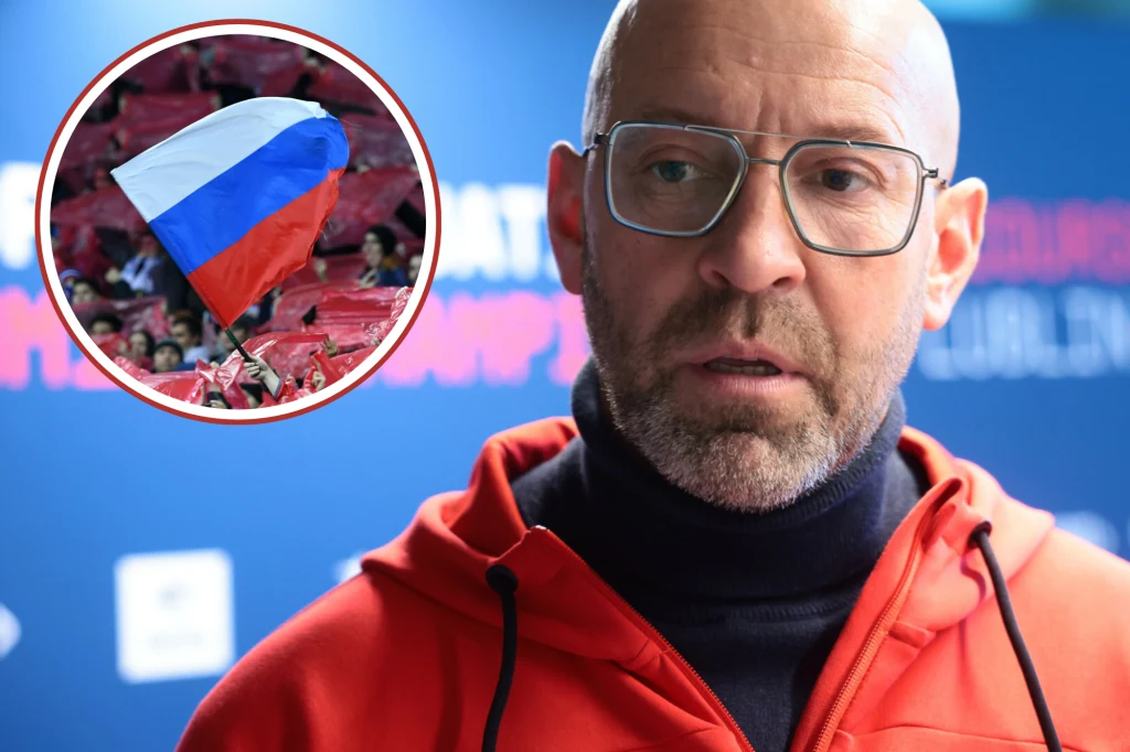 Mężczyzna w okularach i czerwonej bluzie na tle rozmytego niebieskiego tła, z wkomponowanym okrągłym fragmentem przedstawiającym rosyjską flagę unoszoną przez tłum.