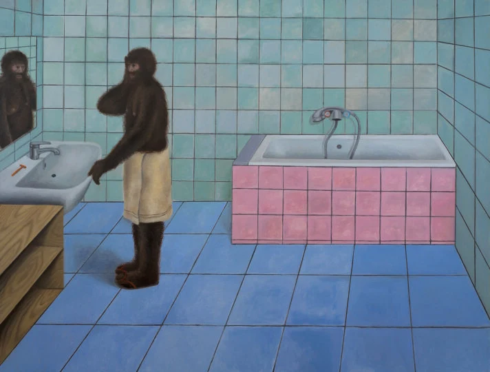 Małpa ubrana w ręcznik stojąca przy umywalce w łazience z różową wanną i ścianami wyłożonymi niebieskimi kafelkami, patrzy na swoje odbicie w lustrze.