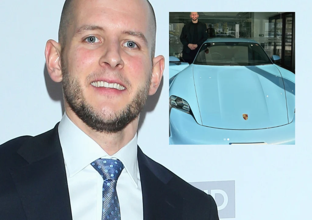 Bartosz Kurek Uśmiechnięty mężczyzna w garniturze na tle jasnego tła, w prawym górnym rogu umieszczona miniatura przedstawiająca niebieskie auto marki Porsche oraz osobę stojącą za samochodem.