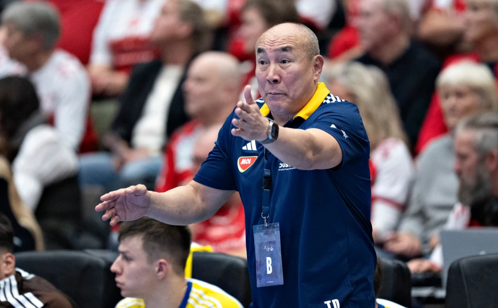 Tałant Dujszebajew Trener w sportowym stroju energicznie gestykuluje podczas meczu, w tle widzowie na trybunach zainteresowani przebiegiem wydarzeń.