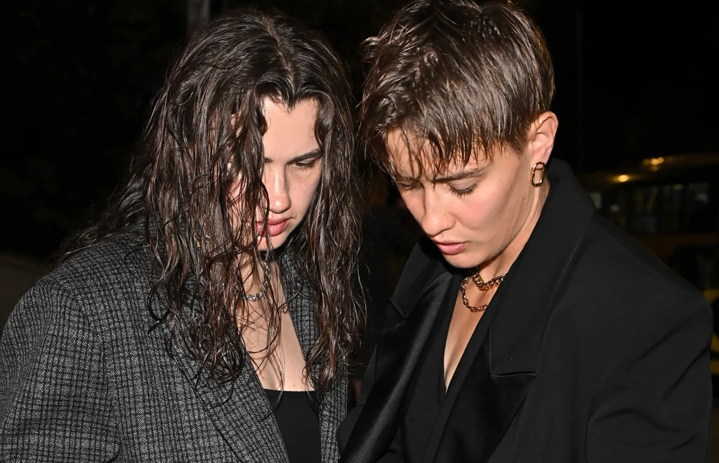 Julia Walczak, Katarzyna Zillmann Dwie młode osoby stoją obok siebie w ciemnym otoczeniu, obie ubrane elegancko, jedna w marynarce z rozpuszczonymi mokrymi włosami, druga z krótką fryzurą i naszyjnikiem.