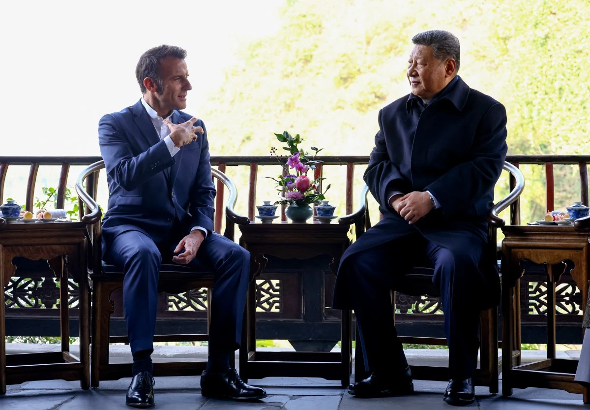 Macron i Xi we wspólnym oświadczeniu wezwali do zawieszenia broni w Ukrainie Dwóch mężczyzn siedzących naprzeciwko siebie przy stolikach, prowadzących rozmowę w eleganckim otoczeniu na tarasie; w tle widoczna roślinność, na stolikach stoją filiżanki oraz ozdobne kompozycje kwiatowe.