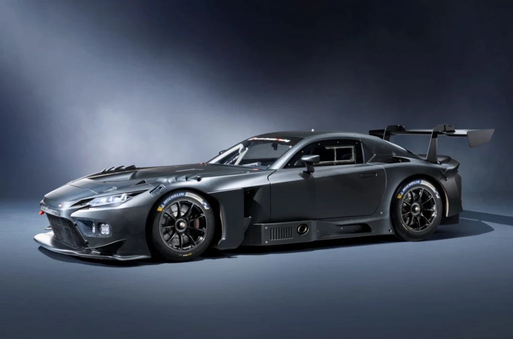 Jednym z kluczowych założeń było obniżenie środka ciężkości samochodu. Czarny, sportowy samochód wyścigowy o aerodynamicznej sylwetce, szerokich oponach i dużym tylnym skrzydle, ustawiony na neutralnym tle. Głębokie przetłoczenia i wloty powietrza podkreślają jego wyścigowy charakter.