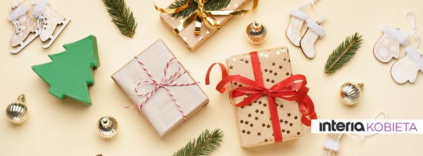 Sięgnij po inspiracje, które pomogą stworzyć ciepłą, świąteczną atmosferę Prezenty ozdobione kolorowymi wstążkami, dekoracje choinkowe, małe złote bombki, gałązki świerku, drewniane ozdoby w kształcie łyżew i choinki na jasnym tle.